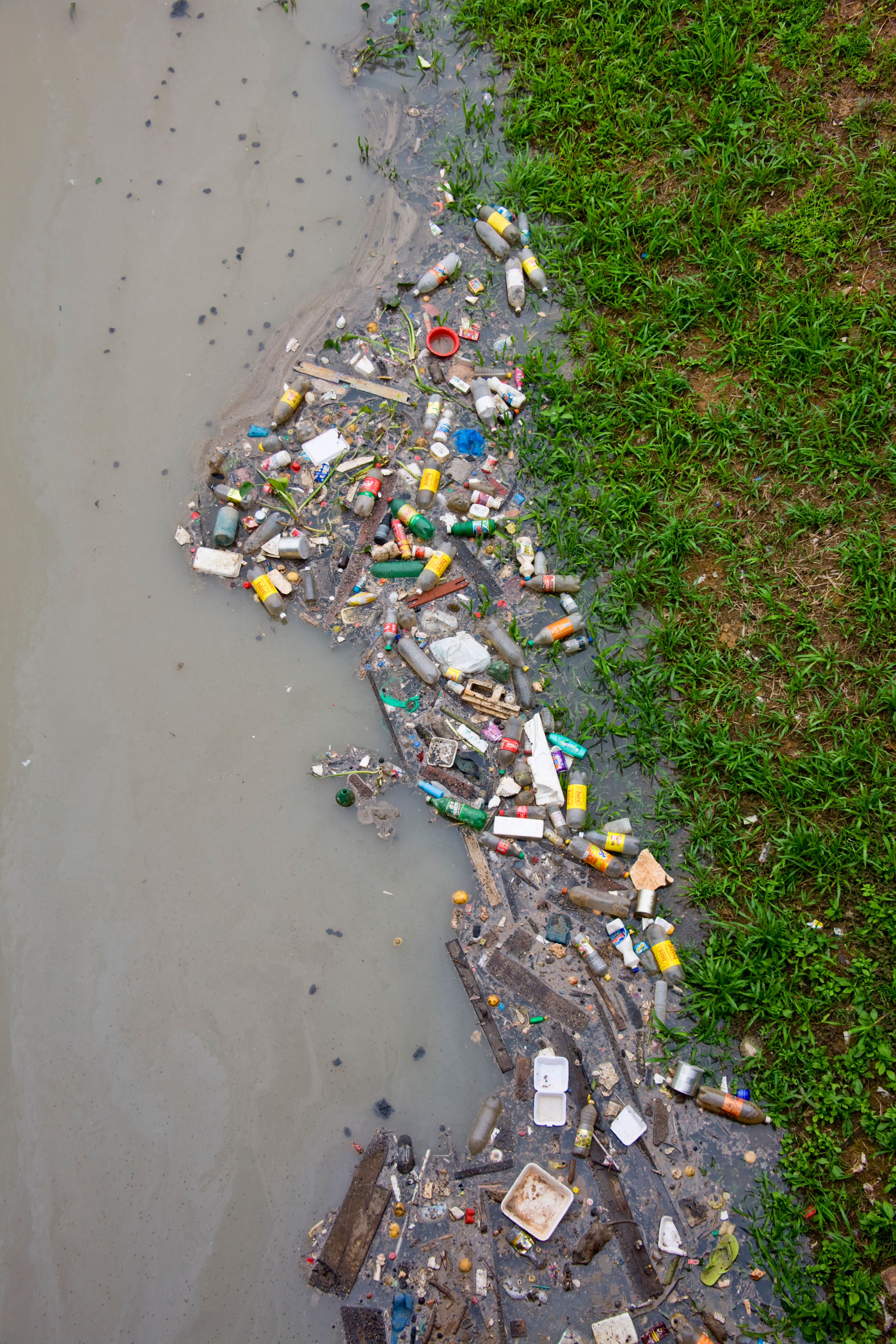 Contaminación de río por residuos plásticos.